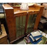 A 1.04m 1930's figured walnut veneered display cabinet with stepped top and glass shelves enclosed