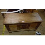 A 96cm oak and mixed wood triple panel coffer style linen chest with carved decoration