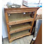 An 86cm vintage standard oak three section modular bookcase with cornice and base, set on bracket