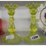 A pair of late 19th Century green uranium glass pressed candlesticks