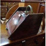 A late Victorian stained oak slope fronted coal box with brass handle and metal liner