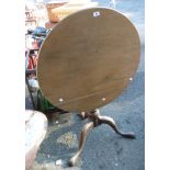 An antique circular tilt-top table on central tripod stand