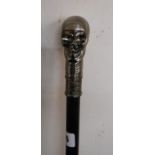 A modern walking stick with skull pattern handle
