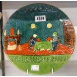 An early 20th Century Belgian pottery dish with embossed decoration depicting a couple reading