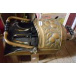 An Arts and Crafts Movement helmet form coal scuttle with repousse work apple decoration and