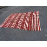 A handmade kelim with red and ivory stripe design, diamond pattern and fringing throughout - 2.5m