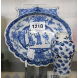 An antique Chinese porcelain dish of shell form painted in blue with three figures to a central