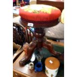 A Victorian mahogany piano stool with upholstered top (not adjustable), set on turned pillar and