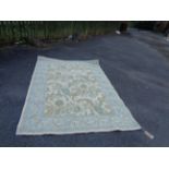 A modern Laura Ashley Belgian machine made rug with torquoise border and sweeping floral design on