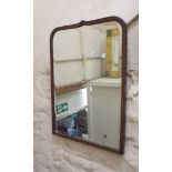 A vintage stained wood framed bevelled wall mirror with shaped top plate
