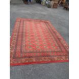 A machine made Mossoul wool rug with repeat gul motif on red ground within repeat border - 3m X 2m