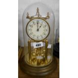 A vintage Kundo anniversary clock with ball pendulum and decorative dial, under glass dome