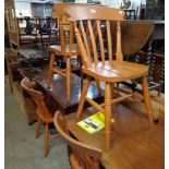 A set of four reproduction stained wood Windsor style kitchen chairs with moulded solid seats, set