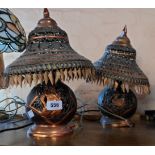 A pair of vintage pierced metal table lamps and shades in the Indian style with coppered effect