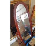 A reproduction stained wood framed cheval mirror with oval plate, set on tuned supports and