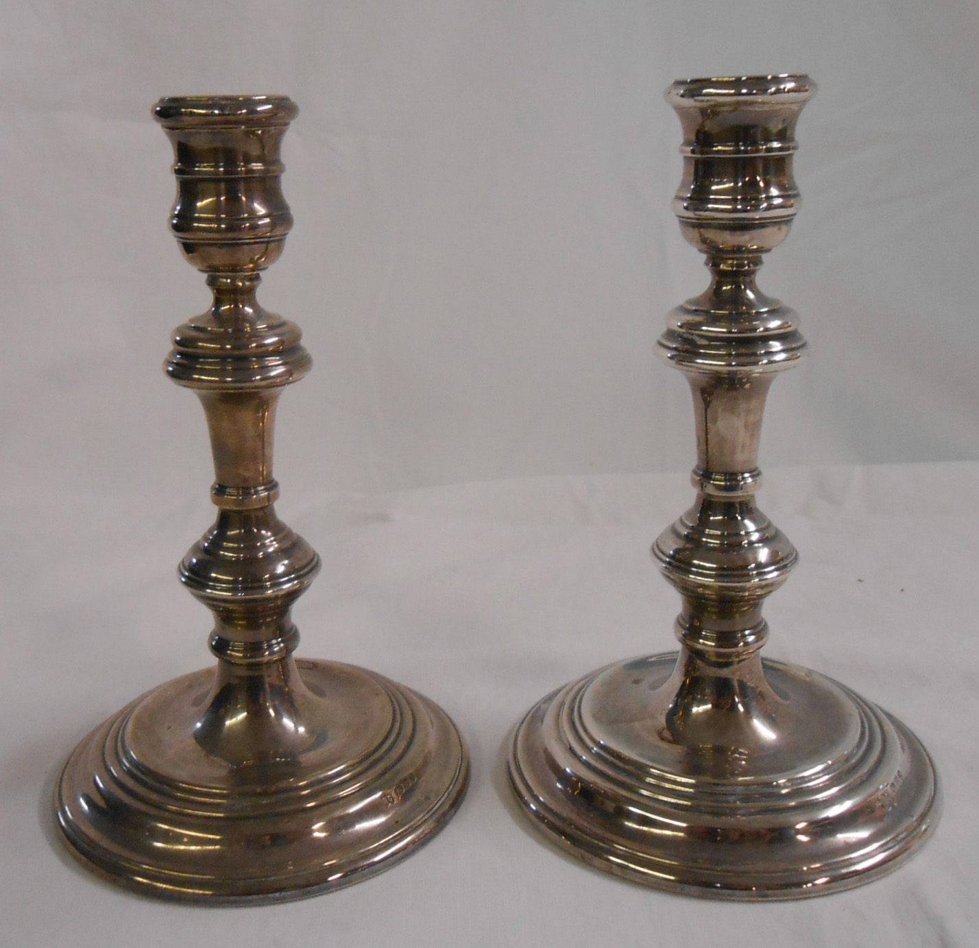 A pair of 17cm silver candlesticks with wide loaded circular bases - London 1972