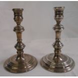 A pair of 17cm silver candlesticks with wide loaded circular bases - London 1972