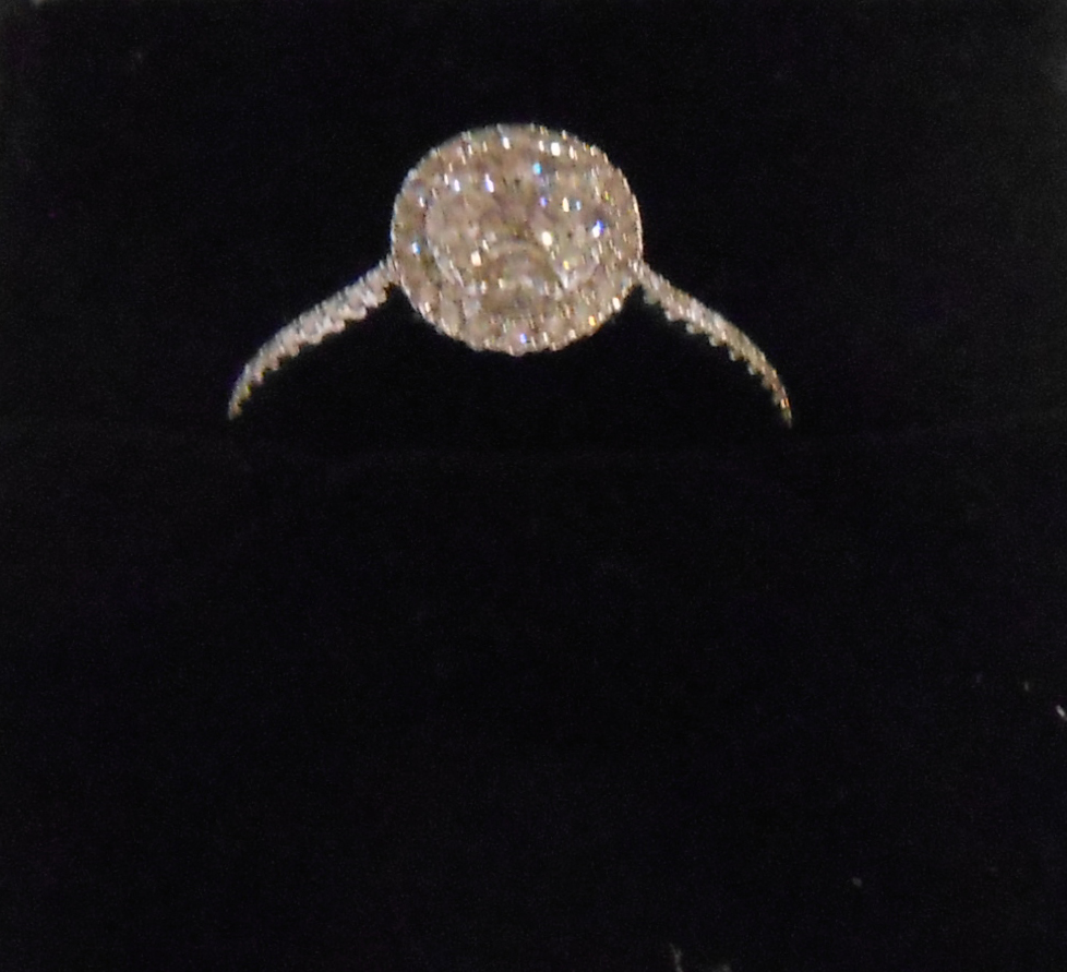 A marked 750/18K white metal ring, set with central diamond cluster and further tiny diamonds to