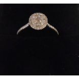 A marked 750/18K white metal ring, set with central diamond cluster and further tiny diamonds to