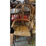 A antique yew and elm Windsor hoop stick back elbow chair with moulded solid elm seat, set on ring