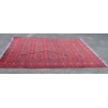An Afghan handmade wool Khan Mohamadi carpet with repeat floral central motif amidst decorative leaf