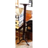 A tall mahogany torchere stand with reeded and turned pillar, set tripod base with pad feet