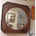 An early 20th Century polished oak framed wall mirror with applied decoration and bevelled