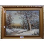 A gilt framed 20th Century oil on canvas, depicting a winter woodland landscape - signed
