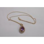 An import marked 375 (9ct.) gold pendant, set with large oval amethyst within a tiny diamond