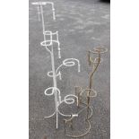 Two vintage wrought iron shop display units with rope twist design and tassel effect finials, one