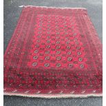 A handmade Afghan rug with repeat central medallion decoration and geometric border - 235cm X 167cm