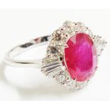 An Art Deco style marked 750 white metal ring, set with large central oval ruby within a brilliant