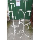 A pair of vintage wrought iron shop display stands of rope twist form and tassel finials with