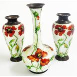 A trio of enamelled small white metal vases comprising an 11.5cm bottle vase and pair of 8.5cm