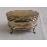 A silver oval ring box with engraved decoration and material lining