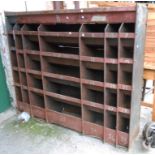 A large free standing industrial metal pigeonhole storage unit with remains of original painted