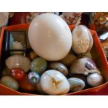A box containing a quantity of carved and other eggs including Serpentine, onyx and cloisonne