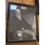 A small monochrome framed print, depicting a seated gentleman