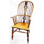 A antique yew and elm Windsor hoop stick back elbow chair with decorative pierced splat back and