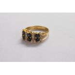 A hallmarked 585 (14ct.) gold ring, set with two rows of three sapphires interspersed with