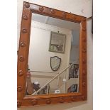 A varnished pine framed oblong wall mirror with applied swirl boss decoration