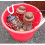 A modern plastic garden weeding bin containing three tilley lamps - various condition