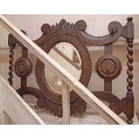 An early 20th Century oak hall mirror with six flanking coat hooks, bevelled oval plate and barley