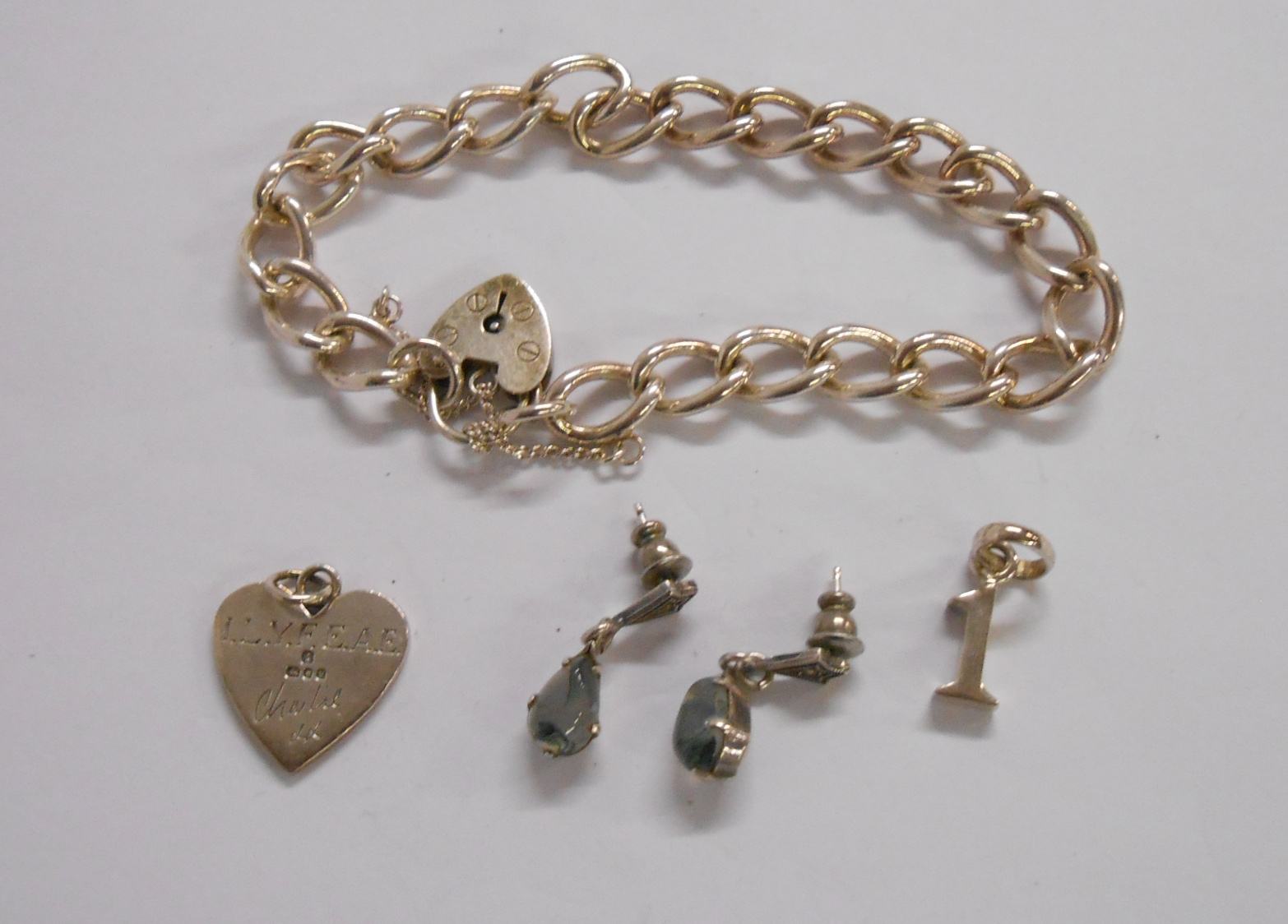 A marked 925 chain with heart shaped padlock - sold with a pair of earrings and two charms