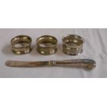 Three silver napkin rings and a silver pistol grip butter knife a/f