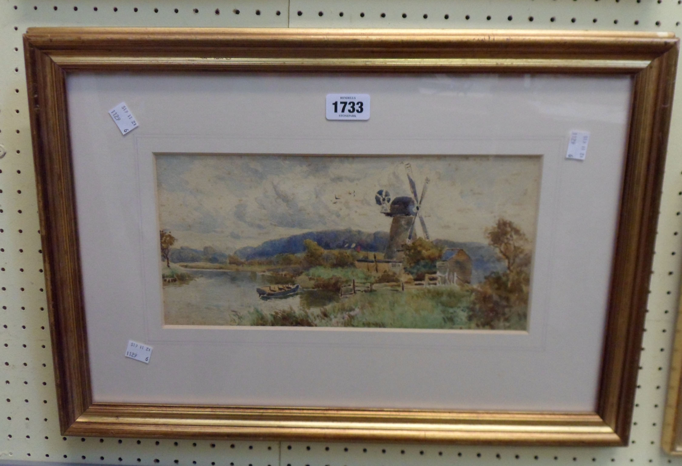 Tom Lloyd: a gilt framed watercolour, depicting a waterside windmill and rowing boat - ink written