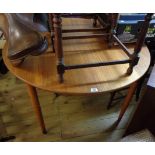 A retro teak effect extending dining table with single leaf, set on tapered legs