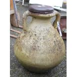 A two handled terracotta pot with wooden lid