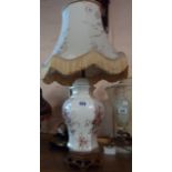 A ceramic table lamp of urn form on carved hardwood base