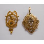 An antique unmarked yellow metal ornate pierced pendant/brooch, set with seed pearls - sold with a